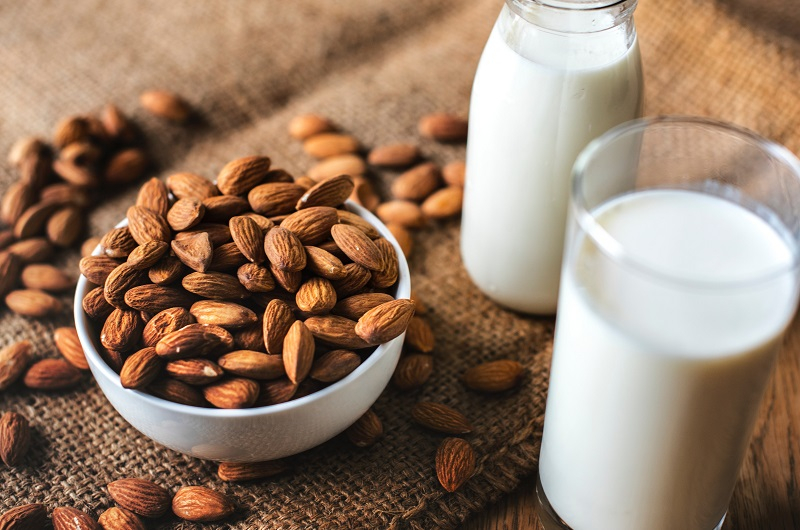 Almonds in a dish and milk in a cup