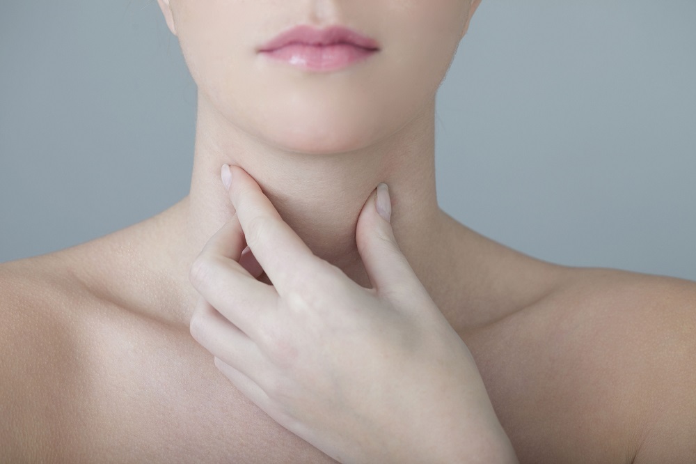 Woman touching her Thyroid