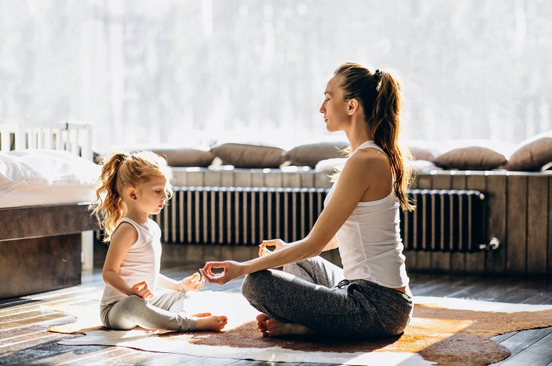 Mother and daughter meditating together