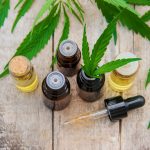 CBD oil in tincture bottles on wooden background