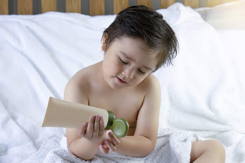 boy applying natural body lotion