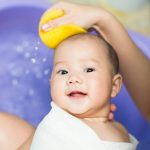 Baby being washed with a sponge without irritants found in baby products