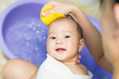 Baby being washed with a sponge without irritants found in baby products